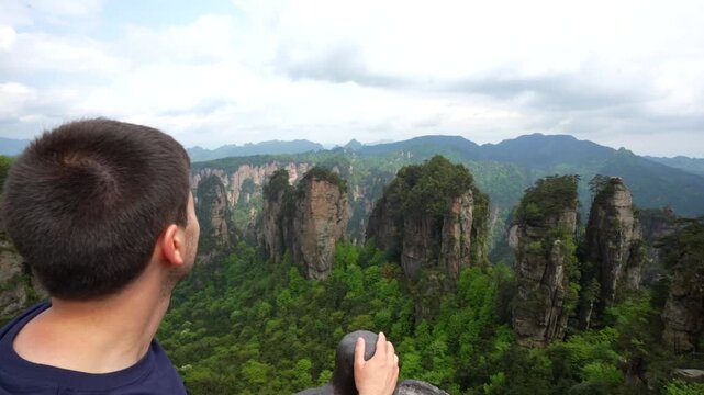 Young man contemplating the stunning landscape of Zhangjiajie National Forest Park in Hunan province