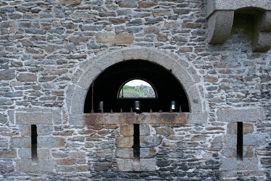 Stone fortress wall with arched opening and defensive embrasures