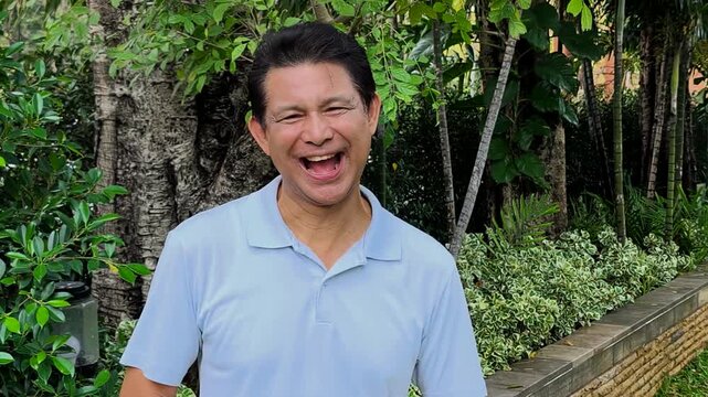 Happy and Healthy Southeast Asian senior man, laughing in happy positive glad mood expression, real asian people model