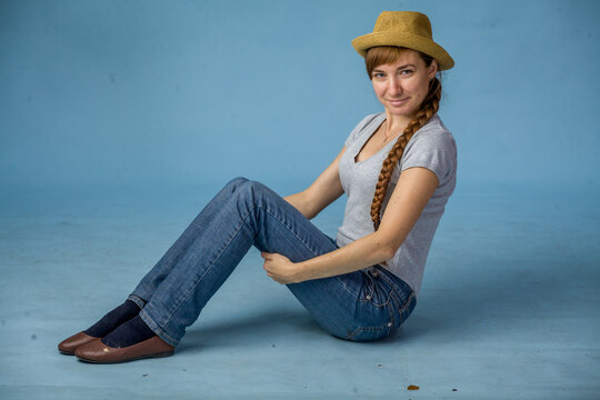 Woman sitting on floor with a playful expression in casual outfit  