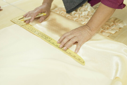someone measures the cloth to be cut