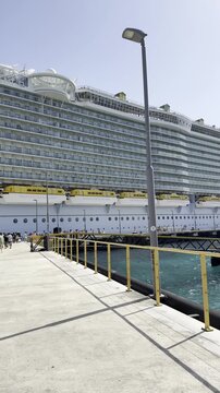 Travelers and tourists disembarking from the cruise liner along the gangway and dock in Curacao.