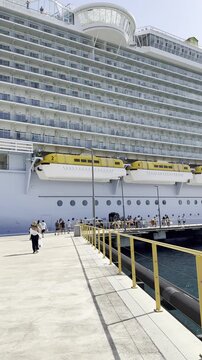 Passengers walking off and disembarking from a cruise ship onto the port dock in Curacao.