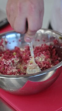 Chef mixing raw minced beef tartare ingredients