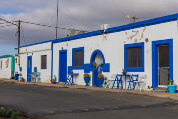 Naklejka premium Traditional white and blue coastal houses with outdoor seating in Canary Islands