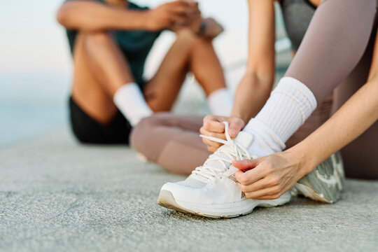 Smiling active young couple jogging exercising and having fun and laughing together taking a breakand using a mobile phone after walking and running in the park, fitness and healhty living concept