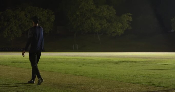 On umpire signal male bowler running, delivering orange ball toward batsman on pitch for match