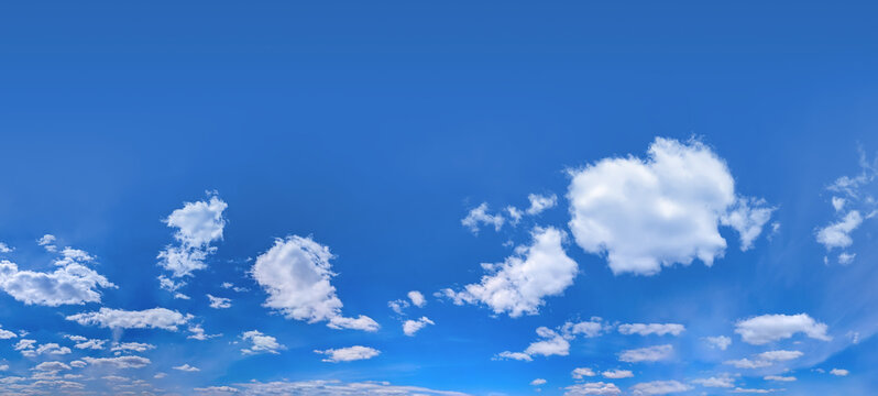 Clouds billowing from center of frame toward viewer, blown by headwind. Neat cumulus cloud against a clear blue summer sky. Wide banner with copy space for text. Zooming into panoramic perspective.