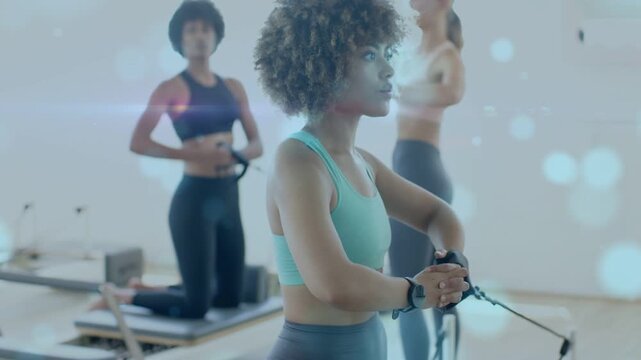 Woman clasping strap at Pilates, breathing and engaging core while bokeh overlays highlight posture