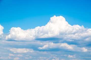 Fototapeta premium Bright Blue Sky With Large Fluffy Cumulus Clouds Over Calm Horizon