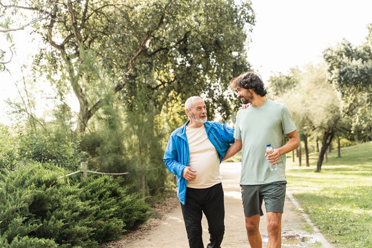 Healthy senior father and son jogging doing sport together, running for active lifestyle and family bonding