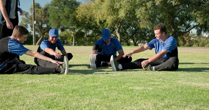 Male athletes stretching legs on field, coach walking in, whistle pointing posture correction