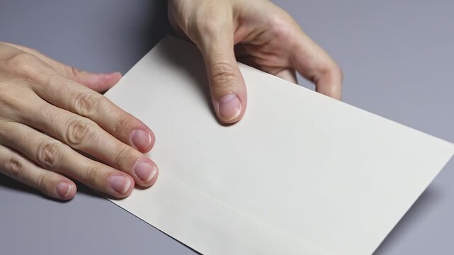 A person's hands put Vietnamese dong (VND) banknotes in the envelope. Concept of money transfer, cash payments, economic crime. Real time footage.
