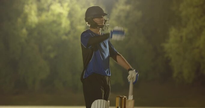 White teenage batsman swinging bat and dropping bat after missing ball as fielders appeal