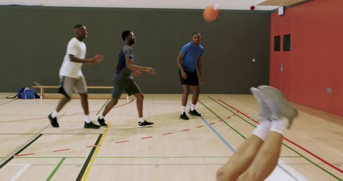 After bounce pass asian man securing basketball by bench, blue sports bag, dribbling in basketball c