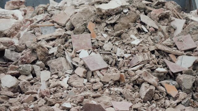 Close-up of a large pile of broken concrete, stones and construction debris inside a waste container. Construction waste and demolition concept. High quality 4k footage