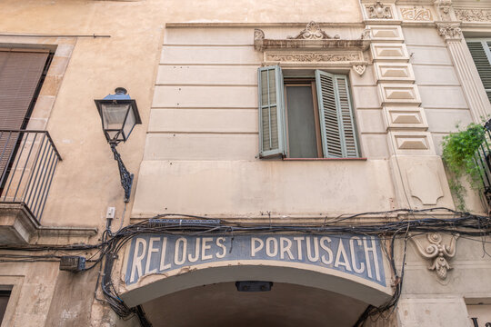 Relojes Portusach Vintage Shop Sign on Archway, Historic Street Architecture, Old Metal Streetlamp, Spain