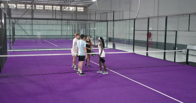 Adult man and african american woman starting rally after greeting, tapping ball and volleying