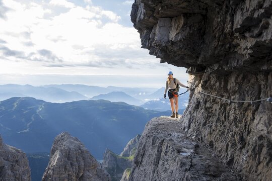 Climbers on a rock band, Bocchette Centrale band trail, via ferrata in the Brenta Mountains, Brenta-Adamello Natural Park, Trentino, Italy