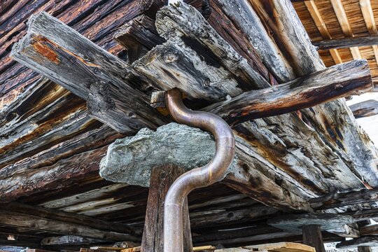 Old weathered hay barn with wooden support, stone slab and copper pipe, Chandolin, Val d'Anniviers, Valais Alps, Canton Valais, Switzerland