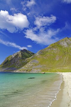 A secluded sandy beach meets turquoise blue sea under picturesque hills and sky, Haukland, Leknes, Vestv&aring;g&oslash;ya, Lofoten, Nordland, Norway
