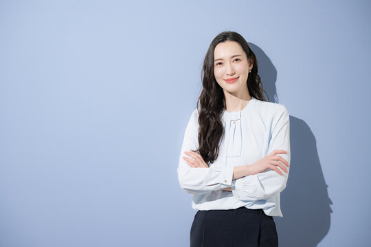 自信や信頼性の高いカッコイイハンサムな女性のビジネスイメージ　カメラ目線で笑顔で腕組み