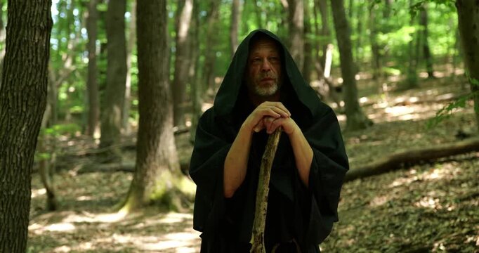 Religious monk rests during a walking pilgrimage among trees maintaining calmness and concentration.
