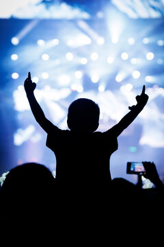 Silhouette of Child at Blue Music Concert with Video Camera