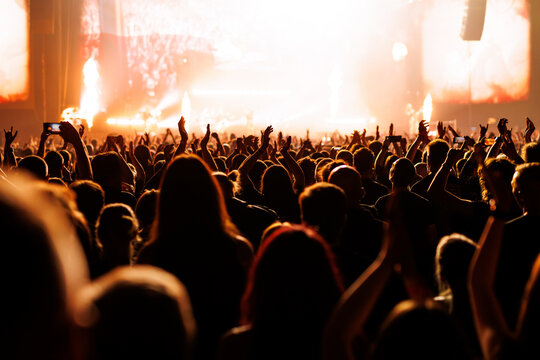 Cheering Crowd with Fists Raised at Orange Fire Concert