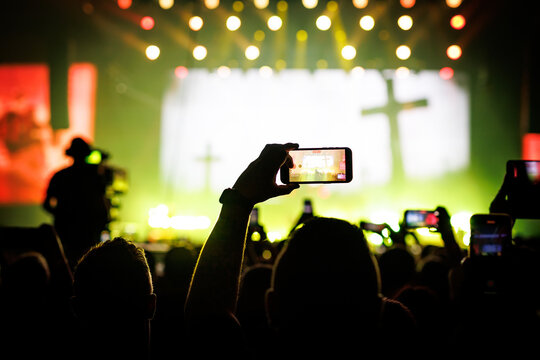 Silhouette of Person Recording Stage Event with Phone
