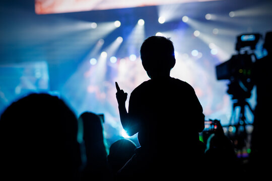 Silhouette of Kid on Shoulders at Concert Show
