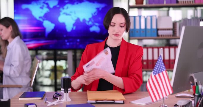 Visa center woman worker places refusal stamp on American visa documents. Serious specialist prepares envelope containing denied visa documents