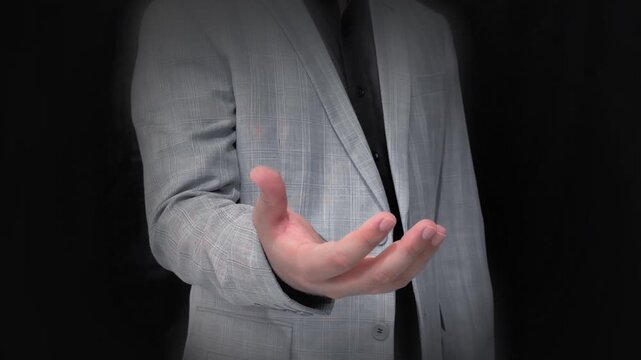 Man in grey suit extending handshake on black background business partnership concept, showing palm