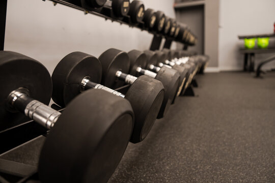 Dumbbells and kettlebells arranged in a modern gym, highlighting strength training equipment used for fitness, bodybuilding, endurance, and functional workout routines.