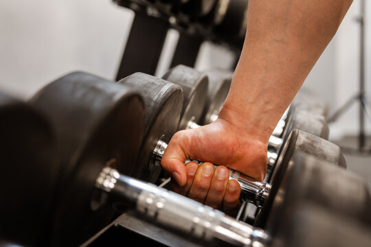 Person exercising in a modern gym environment, using fitness equipment to improve strength, endurance, and overall physical health through structured workout routines.