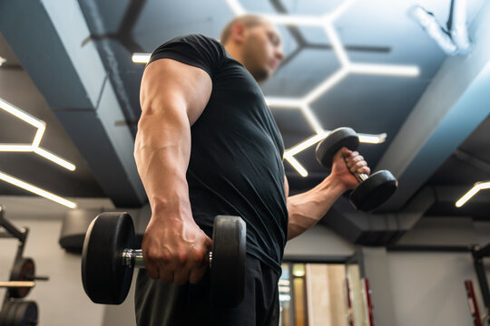 Person exercising in a modern gym environment, using fitness equipment to improve strength, endurance, and overall physical health through structured workout routines.