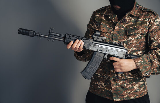 Masked armed individual in urban environment, security incident scenario, law enforcement focus, public safety concern, and high-alert situation concept.