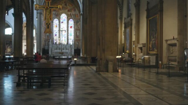 Blurred church with soft bokeh nave and stained glass windows, defocused pews and stone columns; background copyspace backplate calm.