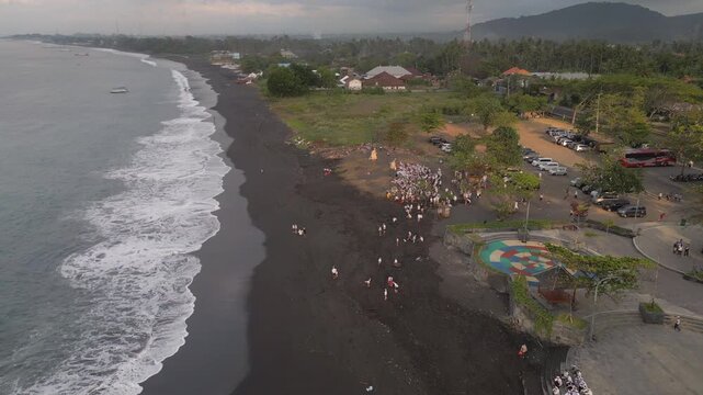 Balinese Mourners Gather On Black Sand Beach For Funeral Indonesia Drone Track In 4K 30FPS