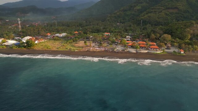 Indonesian Beach Funeral Mourners Gather On Black Sand in Bali Drone Track In Descend 4K 30FPS