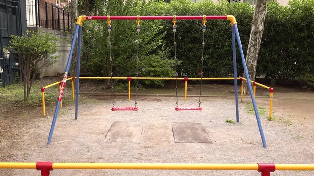 Empty playground swings in a small urban park in Japan