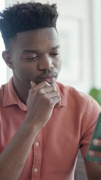 Reading, thinking and black man with phone on couch, message reflection and response idea for chat. Texting, home and male person with mobile for digital communication, social media and meme decision