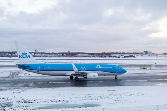 KLM narrowbody jet on snowy Schiphol apron
