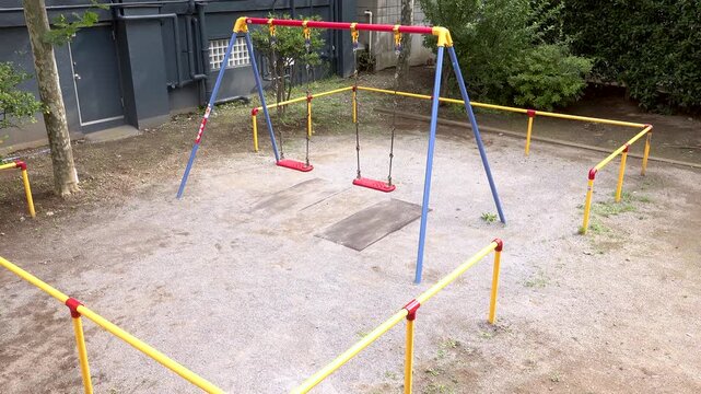 High angle view of empty red swings in a small Japanese urban park