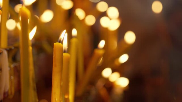 The image depicts a group of candlelight illuminating a wish or prayer on the left side of the frame, with space on the right for text, all amidst a beautiful bokeh effect of candlelight flames.