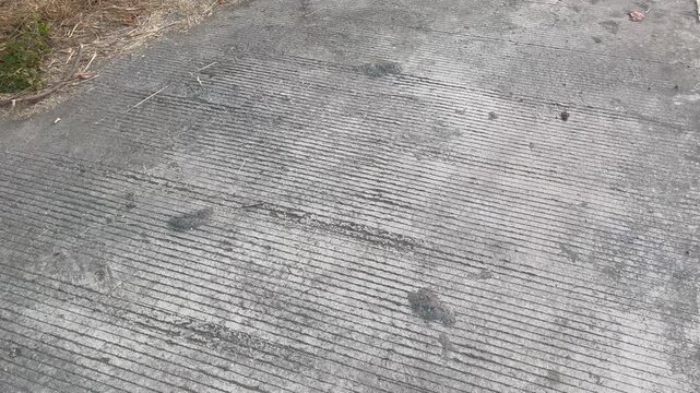 Grey concrete texture with grooved linear patterns outdoors