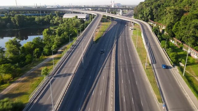 An aerial view of a multi level road junction with bridges on the approach to the city in the early sunny morning