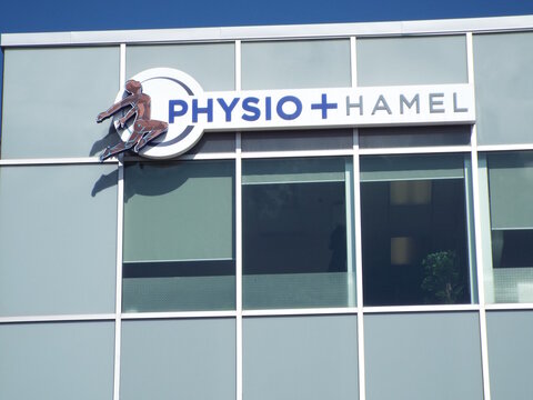 Gatineau, Quebec, Canada &ndash; May 10, 2026: The "Physio + Hamel" sign with a stylized figure icon is mounted on a glass facade on Bd de la Gappe.