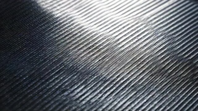 Detailed macro shot of a brushed metal texture featuring parallel lines and shimmering reflections. Contemporary backdrop ideal for technology, industry, or minimalist visual projects