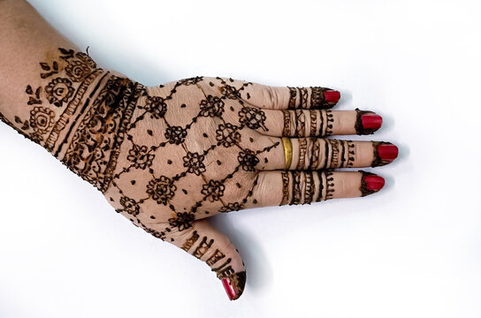 Picture of human hand being decorated with henna tattoo,Decorated Mehendi cone in Indian wedding ceremony